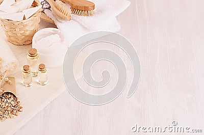 Traditional natural rustic spa white cosmetics products and beige bath accessories on light wood background, top view, border. Stock Photo