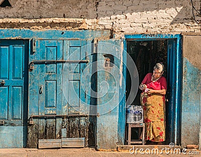 Traditional Nepali Village life. Woman selling water Editorial Stock Photo