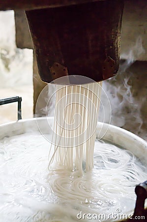 Traditional noodles making on a vintage machine Stock Photo