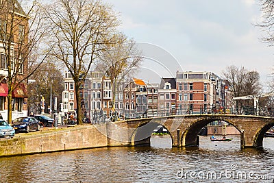 Traditional old houses, canal, bridge, bikes in Amsterdam, Netherlands Editorial Stock Photo