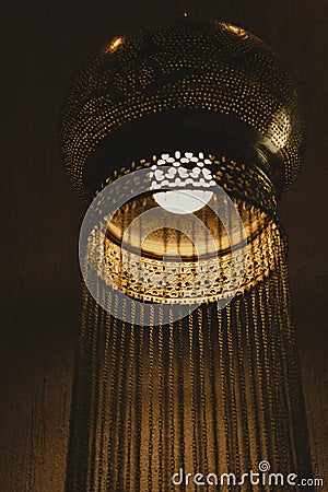 Traditional Oriental lamp. Lacy metal Arabic hanging lamp with long chains. Concept for Moroccan and Arabian culture and Stock Photo