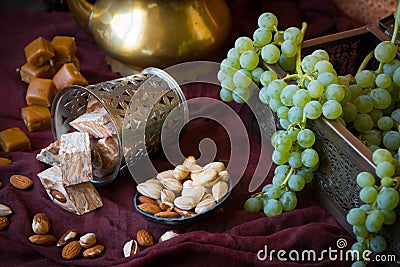 Traditional oriental sweets, nuts and grape. Metal and copper kitchen tools Stock Photo