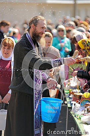 Traditional orthodox paschal ritual - priest blessing easter egg Editorial Stock Photo