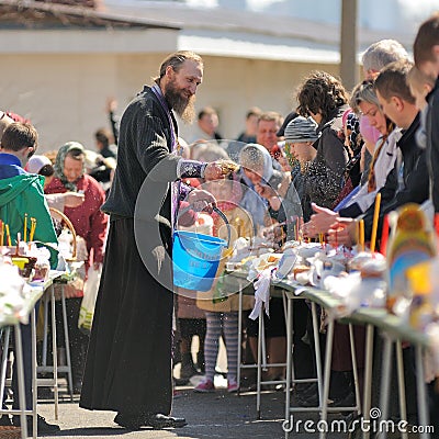 Traditional orthodox paschal ritual - priest blessing easter egg Editorial Stock Photo