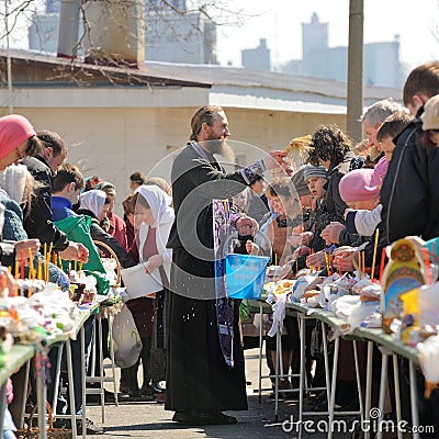 Traditional orthodox paschal ritual - priest blessing easter egg Editorial Stock Photo