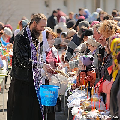 Traditional orthodox paschal ritual - priest blessing easter egg Editorial Stock Photo