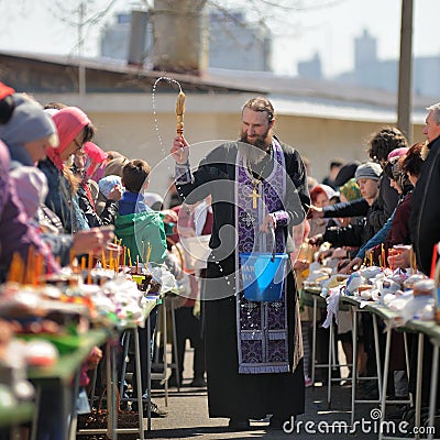 Traditional orthodox paschal ritual - priest blessing easter egg Editorial Stock Photo