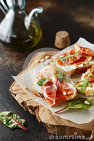 Traditional parma cured ham antipasto. Bruschetta set with Parma Ham and Parmesan Cheese. Small sandwiches with prosciutto, Stock Photo