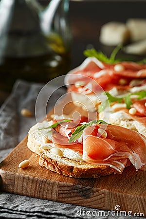 Traditional parma cured ham antipasto. Bruschetta set with Parma Ham and Parmesan Cheese. Small sandwiches with prosciutto, Stock Photo