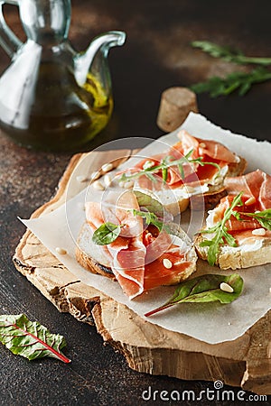 Traditional parma cured ham antipasto. Bruschetta set with Parma Ham and Parmesan Cheese. Small sandwiches with prosciutto, Stock Photo