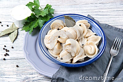 Traditional pelmeni, ravioli, dumplings filled with meat on wooden background, russian kitchen Stock Photo