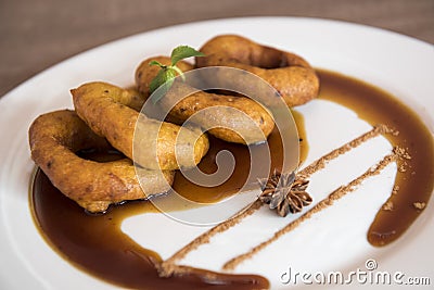 Traditional peruvian dessert Picarones. Made of sweet potato, pumpkin and wheat flour. Fried an served whit honey figs. Stock Photo