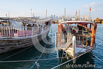 Traditional Qatari dhow boats with the skyline of Doha West Bay skyscrapers Editorial Stock Photo