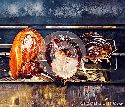 Traditional roasted shank cooking on charcoal spit roaster Stock Photo