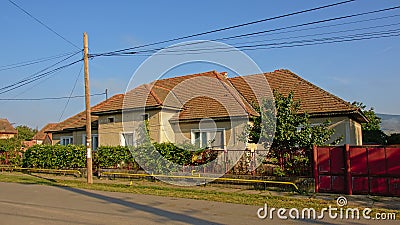 Traditional Romanian farm along a street with electical wiring in the air in the village of Aurel Vlaicu Editorial Stock Photo