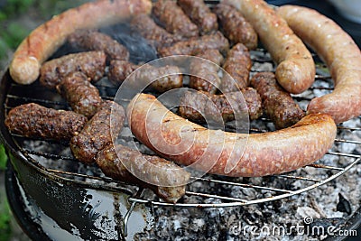 Traditional Romanian food, barbecue with grilled meat rolls, mititei or mici (beef, pork and lamb meat) and sausages Stock Photo