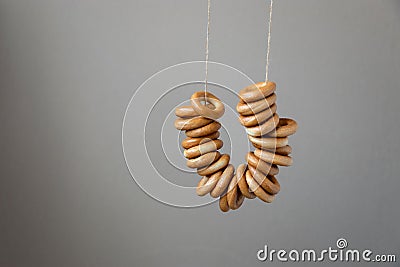 Traditional russian tasty bagels on a rope against a gray wall Stock Photo