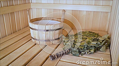 Traditional sauna stuff - birch whisk and a bucket. Wooden bucket and whisk in the sauna Stock Photo