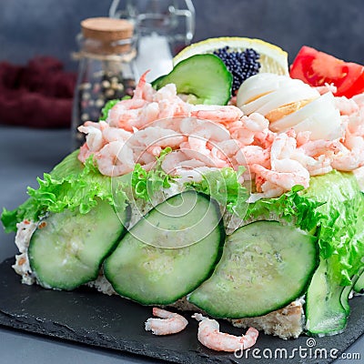 Traditional savory swedish sandwich cake Smorgastorta with bread, shrimps, eggs, caviar, dill, mayonnaise, cucumber and lettuce, Stock Photo