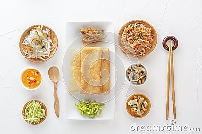 Traditional snacks of Chinese cuisine Dim Sum - tortillas - bings in a plate on a white background, spicy salads, vegetables Stock Photo