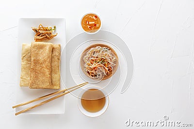 Traditional snacks of Chinese cuisine Dim Sum - tortillas - bings in a plate on a white background, spicy salads, vegetables Stock Photo