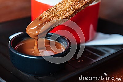 Traditional Spanish dessert Churros with sugar and cinnamon. Dipping in chocolate sauce Stock Photo