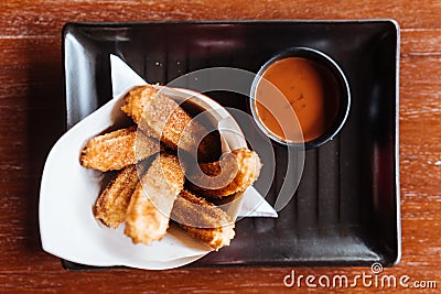 Traditional Spanish dessert Churros with sugar and cinnamon. Served with chocolate sauce Stock Photo