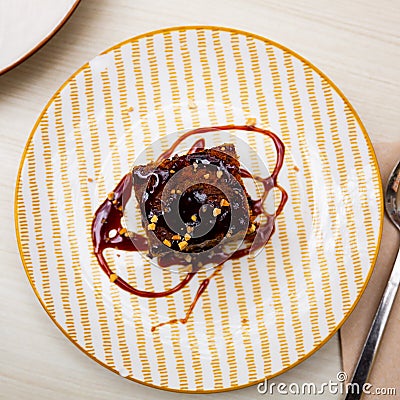 Traditional spanish dessert Tarta de zanahoria. Slice of carrot cake with chocolate syrup Stock Photo