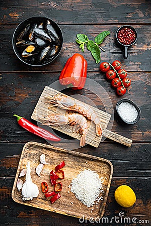 Traditional spanish seafood paella ingredients on old wooden dark table, top view Stock Photo