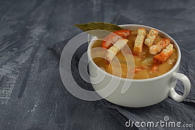 Traditional split pea soup with hard chucks in plate with handles. Stock Photo