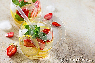 Traditional summer Mojito drink with lemon and strawberry with copy space on brown stone background. Stock Photo