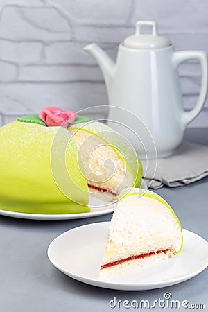 Traditional Swedish dessert Princess cake with green marzipan cover and pink rose decoration, sliced, on gray background, vertical Stock Photo