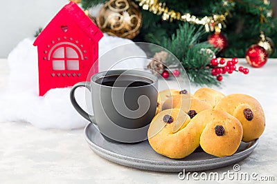 Traditional Swedish and scandinavian Christmas saffron buns Lussekatter with cup of coffee, Christmas decoration on background, Stock Photo