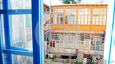 Traditional Tbilisi back yard impression - wooden facade, blue and brown windows and washing ropes Stock Photo