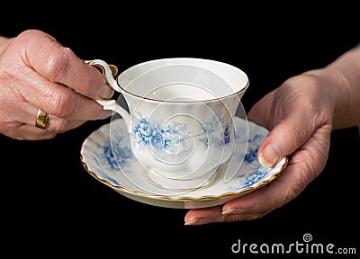 Traditional teacup and saucer held in English lady`s hands. Stock Photo