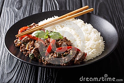 Traditional Thai Basil Beef, or Pad Gra Prow over white rice closeup on a plate. horizontal Stock Photo