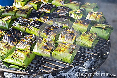 Traditional Thai food style, Grill marinate fish with herbs wrap with banana leaves Stock Photo