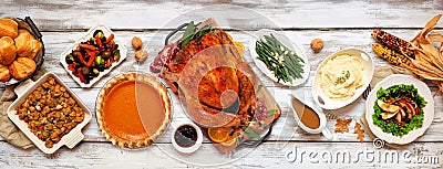 Traditional Thanksgiving turkey dinner above table scene on a rustic white wood banner Stock Photo