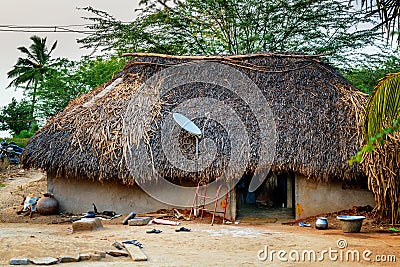 Traditional thatch hut with satellite TV dish Stock Photo