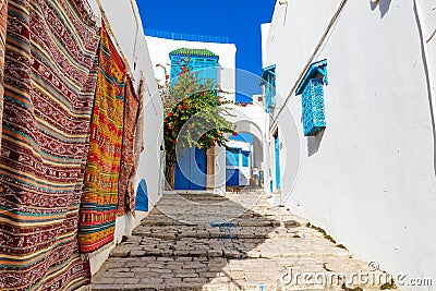 Traditional Tunesian carpets hanging on blue walls in resort town Sidi Bou Said. Tunisia, North Africa Stock Photo