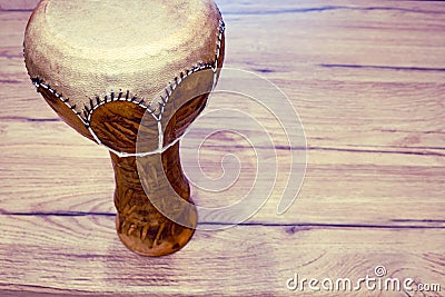 Traditional Tunisian drum made of clay and camel skin. Clay drum with leather membrane on a wooden table, copy space for text Stock Photo
