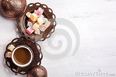 Traditional Turkish coffee and Turkish delight on white shabby wooden background. Top view Stock Photo