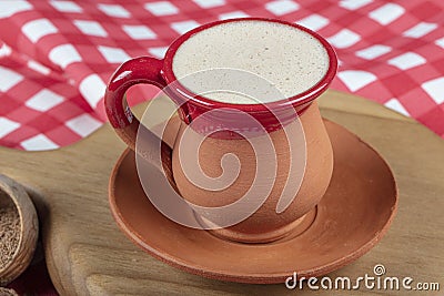 Traditional Turkish Dibek coffee in coffee cup on wooden table. Turkish dibek coffee grinded in a large stone mortar with the Stock Photo