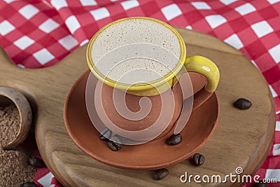 Traditional Turkish Dibek coffee in coffee cup on wooden table. Turkish dibek coffee grinded in a large stone mortar with the Stock Photo