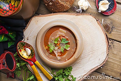 Traditional Ukrainian beet soup borscht in wooden bowl with garlic buns pampushka and dry cured pork belly on rustic wooden table Stock Photo