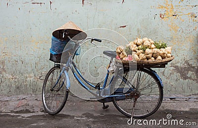 Traditional Vietnamese bicycle load with vegetables and conical hat rested on the handlebar. Stock Photo