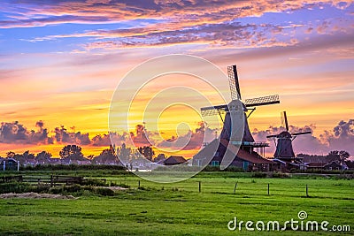 Traditional village with dutch windmills and river at sunset, Holland, Netherlands. Stock Photo