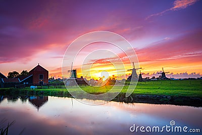 Traditional village with dutch windmills and river at sunset, Holland, Netherlands. Stock Photo