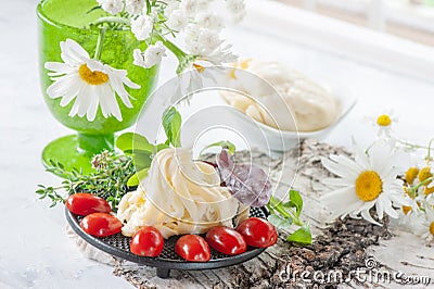Traditional white soft fibrous Cecil cheese lies on a plate. The cheese is decorated with ripe tomatoes and gooseberries Stock Photo