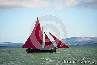 Traditional wooden boat with red sail. Stock Photo